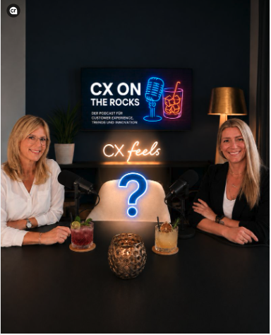 Anika Tannebaum und Annika Schmidt sitzen lächelnd an einem Tisch mit Cocktails, im Hintergrund ein Leuchtschild "CX on the Rocks" und "CX feels" sowie ein leuchtendes Fragezeichen zwischen ihnen als Symbol für den gesuchten Podcast-Gast